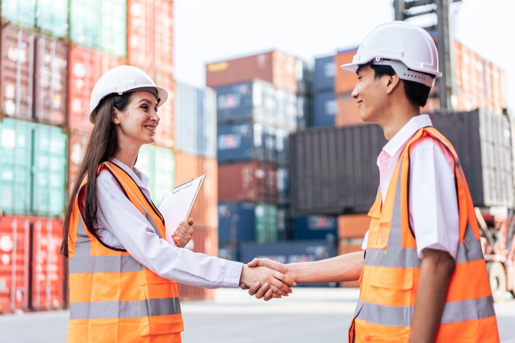 Caucasian business woman and Asian business man work in terminal port.