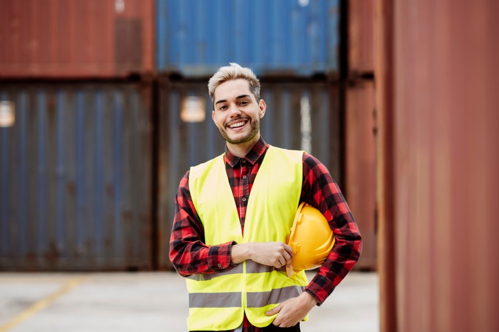 young man loading goods from the dock, young worker in the logistics port.